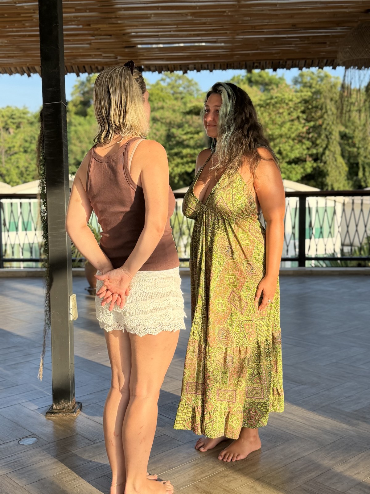 שתי מטיילות משוחחות על מרפסת עץ מול הירוק